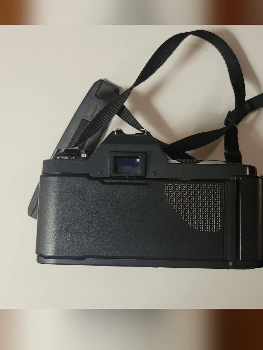 Canon black film camera with 50mm FD f/1.8 lens and neck strap